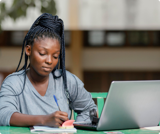 A lady sitting and working on a laptop.